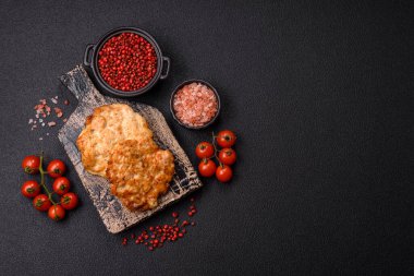 Lezzetli kızarmış domuz ya da koyu beton arka planda tuz ve baharatla ekilmiş tavuk pirzolası.