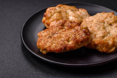 Lezzetli kızarmış domuz ya da koyu beton arka planda tuz ve baharatla ekilmiş tavuk pirzolası.