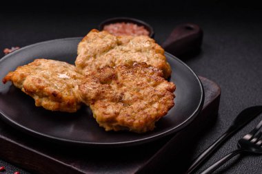 Lezzetli kızarmış domuz ya da koyu beton arka planda tuz ve baharatla ekilmiş tavuk pirzolası.