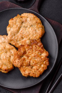 Lezzetli kızarmış domuz ya da koyu beton arka planda tuz ve baharatla ekilmiş tavuk pirzolası.