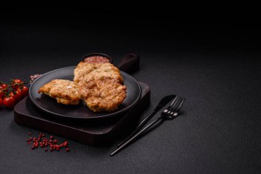 Lezzetli kızarmış domuz ya da koyu beton arka planda tuz ve baharatla ekilmiş tavuk pirzolası.