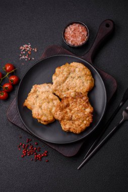 Lezzetli kızarmış domuz ya da koyu beton arka planda tuz ve baharatla ekilmiş tavuk pirzolası.