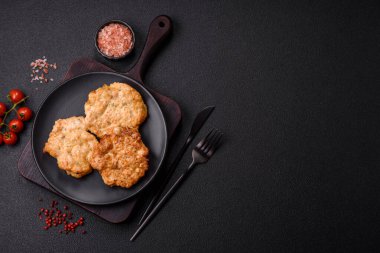 Lezzetli kızarmış domuz ya da koyu beton arka planda tuz ve baharatla ekilmiş tavuk pirzolası.