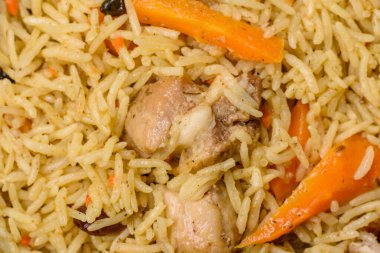 Lezzetli taze pilav, pirinç, havuç, et, soğan, baharat ve böğürtlen ile koyu beton arka planda seramik bir tabakta.