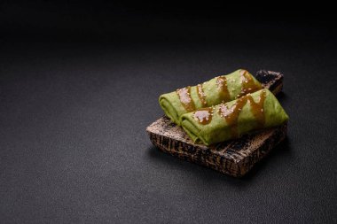 Koyu beton bir arka planda tavuk, mantar, tuz ve baharatla doldurulmuş ıspanaklı krep.