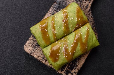 Koyu beton bir arka planda tavuk, mantar, tuz ve baharatla doldurulmuş ıspanaklı krep.