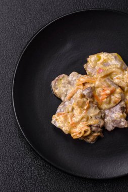 Lezzetli haşlanmış biftek ya da havuç, soğan, ekşi krema ve baharatlı seramik tabakta dilimlenmiş domuz dili.