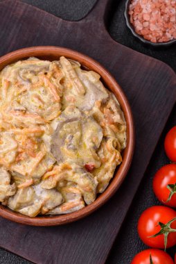 Lezzetli haşlanmış biftek ya da havuç, soğan, ekşi krema ve baharatlı seramik tabakta dilimlenmiş domuz dili.