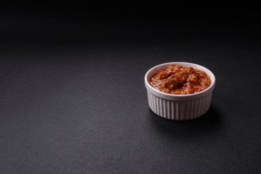 Tayland yemeği et, acı biber, domates sosu ve koyu beton arka planda susam.