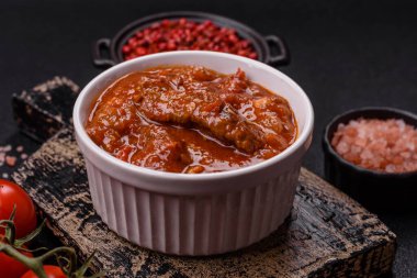 Tayland yemeği et, acı biber, domates sosu ve koyu beton arka planda susam.