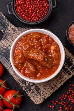 Tayland yemeği et, acı biber, domates sosu ve koyu beton arka planda susam.