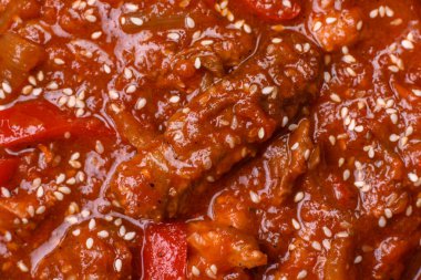 Tayland yemeği et, acı biber, domates sosu ve koyu beton arka planda susam.