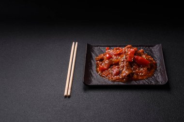 Tayland yemeği et, acı biber, domates sosu ve koyu beton arka planda susam.