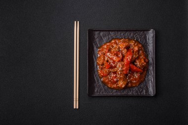 Tayland yemeği et, acı biber, domates sosu ve koyu beton arka planda susam.