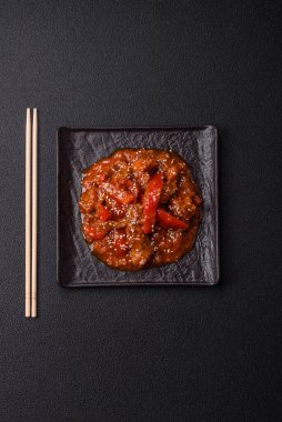 Tayland yemeği et, acı biber, domates sosu ve koyu beton arka planda susam.