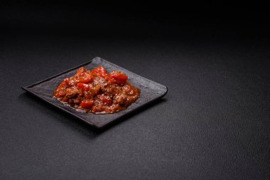 Tayland yemeği et, acı biber, domates sosu ve koyu beton arka planda susam.