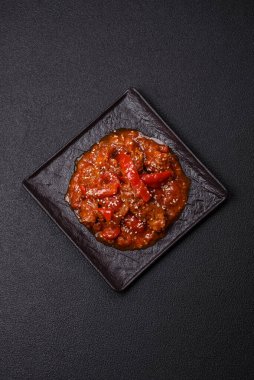 Tayland yemeği et, acı biber, domates sosu ve koyu beton arka planda susam.