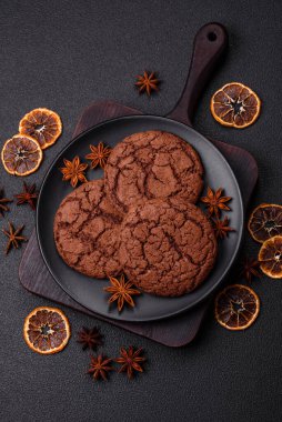 Lezzetli gevrek yulaf ezmeli kurabiyeler ve koyu beton arka planda çikolata.