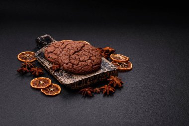 Lezzetli gevrek yulaf ezmeli kurabiyeler ve koyu beton arka planda çikolata.