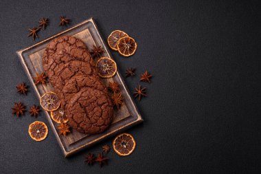 Lezzetli gevrek yulaf ezmeli kurabiyeler ve koyu beton arka planda çikolata.