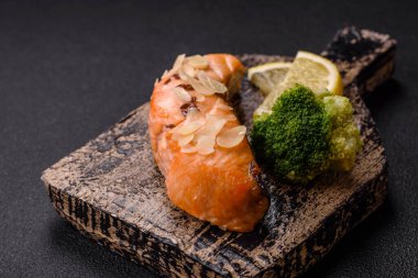 Koyu beton arka planda pirinç, brokoli, tuz ve baharatla haşlanmış somon.