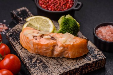 Koyu beton arka planda pirinç, brokoli, tuz ve baharatla haşlanmış somon.