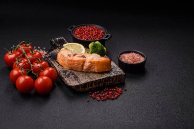 Koyu beton arka planda pirinç, brokoli, tuz ve baharatla haşlanmış somon.