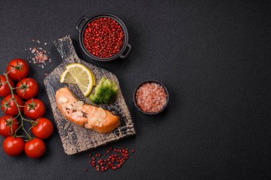 Koyu beton arka planda pirinç, brokoli, tuz ve baharatla haşlanmış somon.