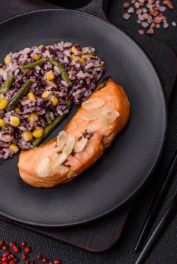 Koyu beton arka planda pirinç, brokoli, tuz ve baharatla haşlanmış somon.