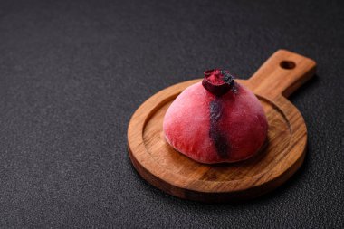 Renkli pirinç hamuru kabuğu ve koyu beton arka planda meyveli lezzetli Japon mochi tatlısı.