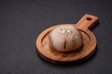 Renkli pirinç hamuru kabuğu ve koyu beton arka planda meyveli lezzetli Japon mochi tatlısı.