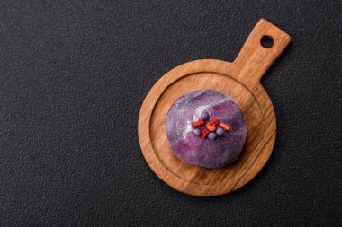 Renkli pirinç hamuru kabuğu ve koyu beton arka planda meyveli lezzetli Japon mochi tatlısı.