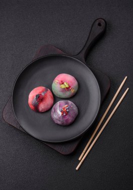 Renkli pirinç hamuru kabuğu ve koyu beton arka planda meyveli lezzetli Japon mochi tatlısı.