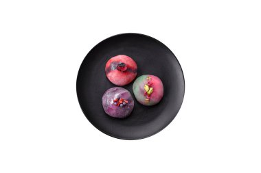 Renkli pirinç hamuru kabuğu ve koyu beton arka planda meyveli lezzetli Japon mochi tatlısı.