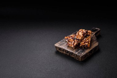 Fındıklı lezzetli besin çubukları, koyu beton arka planda kurutulmuş böğürtlen glütensiz.