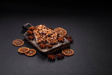 Fındıklı lezzetli besin çubukları, koyu beton arka planda kurutulmuş böğürtlen glütensiz.