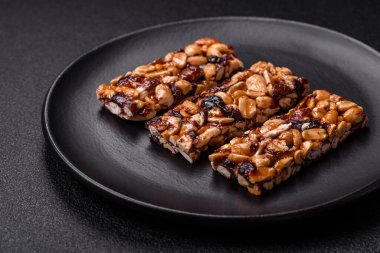 Fındıklı lezzetli besin çubukları, koyu beton arka planda kurutulmuş böğürtlen glütensiz.