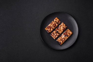 Fındıklı lezzetli besin çubukları, koyu beton arka planda kurutulmuş böğürtlen glütensiz.