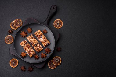 Fındıklı lezzetli besin çubukları, koyu beton arka planda kurutulmuş böğürtlen glütensiz.