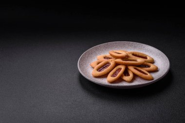 Lezzetli, çıtır çıtır kurabiyeler. Ortasında reçel var.