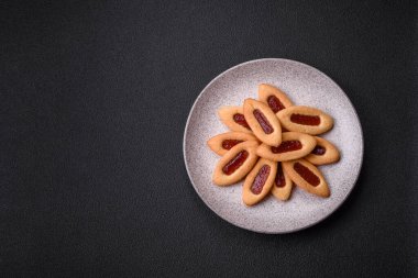 Lezzetli, çıtır çıtır kurabiyeler. Ortasında reçel var.