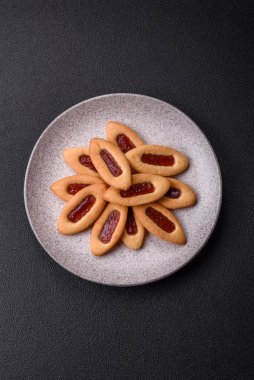 Lezzetli, çıtır çıtır kurabiyeler. Ortasında reçel var.