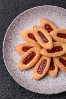 Lezzetli, çıtır çıtır kurabiyeler. Ortasında reçel var.