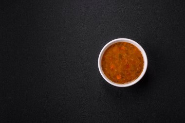 Sebzeli leziz sıcak domates çorbası, vejetaryen yemeği ve koyu betondan bir arka plan.