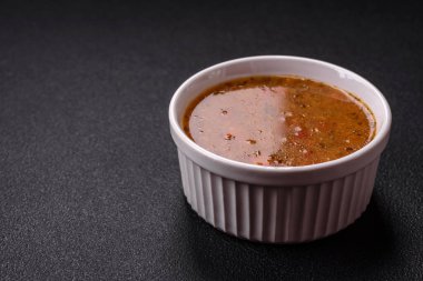 Sebzeli leziz sıcak domates çorbası, vejetaryen yemeği ve koyu betondan bir arka plan.