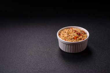 Lezzetli, haşlanmış buğday lapası, sebzeli kuskus, vejetaryen yemeği, koyu beton arka planda.