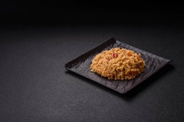 Lezzetli, haşlanmış buğday lapası, sebzeli kuskus, vejetaryen yemeği, koyu beton arka planda.