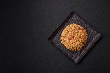 Lezzetli, haşlanmış buğday lapası, sebzeli kuskus, vejetaryen yemeği, koyu beton arka planda.