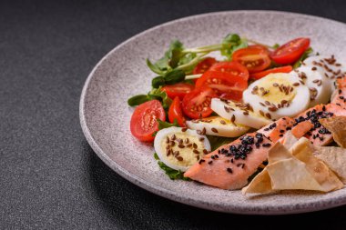 Somon, marul, domates, yumurta, tuz ve baharatlı leziz taze sezar salatası.