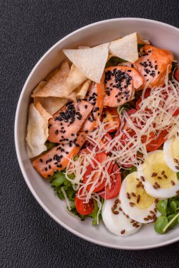 Somon, marul, domates, yumurta, tuz ve baharatlı leziz taze sezar salatası.